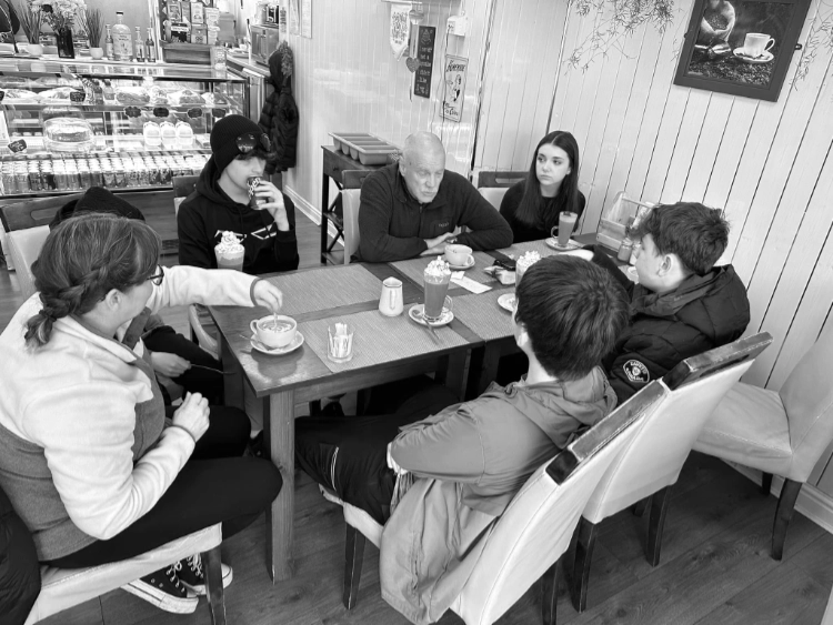 A group of young people having coffee with a volunteer